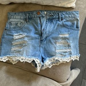 High waisted distressed jean shorts with lace detail